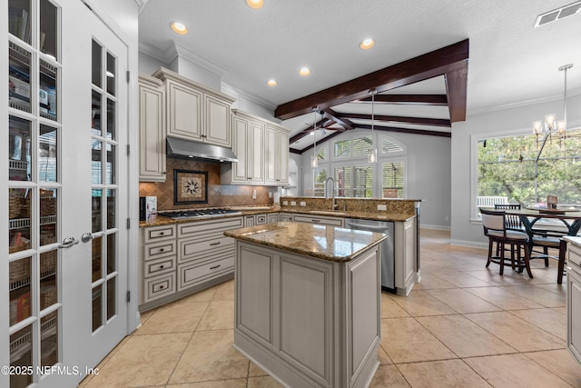 kitchen with visible vents, under cabinet range hood, cream cabinets, stainless steel appliances, and a peninsula