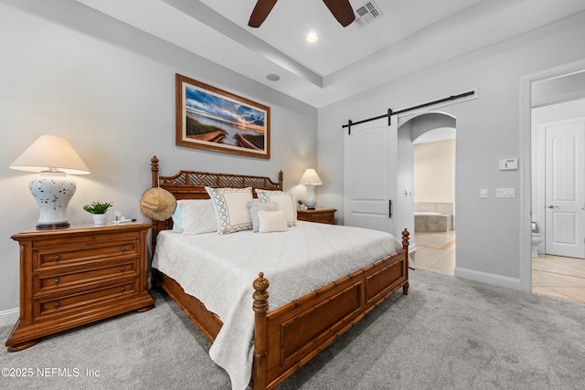 bedroom with visible vents, baseboards, arched walkways, ensuite bathroom, and light colored carpet