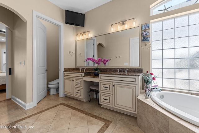 full bathroom featuring tile patterned floors, baseboards, toilet, and a healthy amount of sunlight