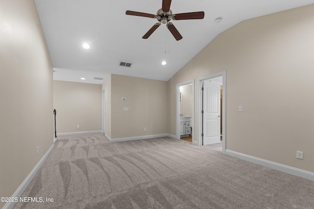 empty room featuring visible vents, a ceiling fan, baseboards, light colored carpet, and vaulted ceiling