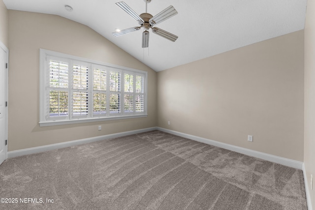 spare room featuring vaulted ceiling, a ceiling fan, baseboards, and carpet floors