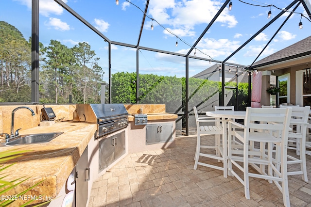 view of patio / terrace featuring glass enclosure, outdoor dining space, area for grilling, a sink, and grilling area