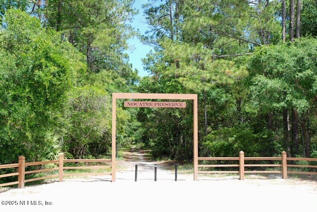 exterior space featuring a forest view and fence