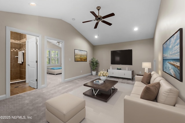 living area featuring ceiling fan, vaulted ceiling, light carpet, and baseboards
