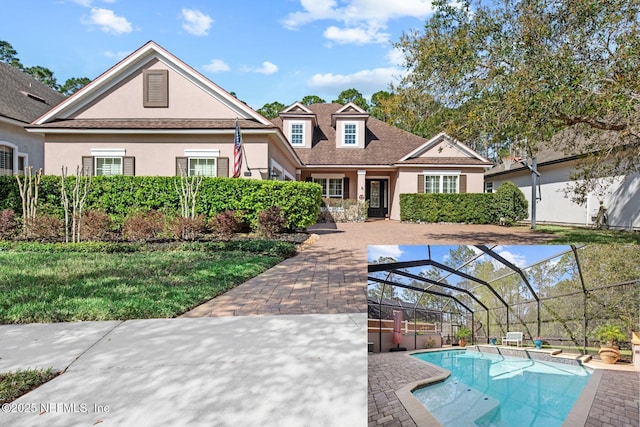 exterior space featuring a yard, stucco siding, glass enclosure, a patio, and an outdoor pool