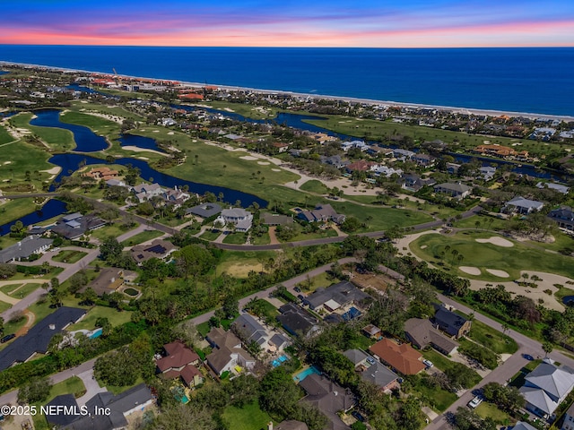 drone / aerial view featuring view of golf course, a water view, and a residential view