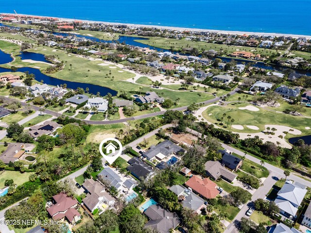 birds eye view of property with golf course view, a water view, and a residential view