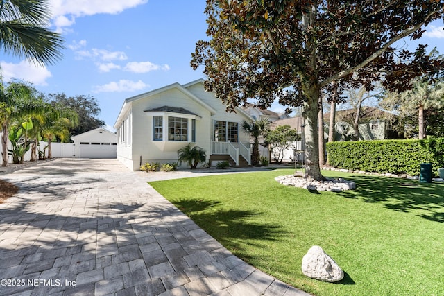 view of front of home featuring an outbuilding, a garage, a front lawn, and fence