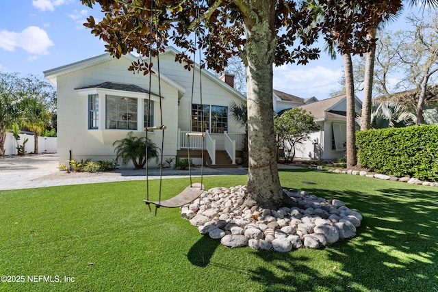 view of front of home with a front lawn, fence, and a chimney