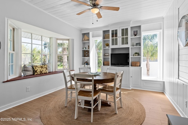 dining area with a wealth of natural light, light wood-style flooring, wood ceiling, and crown molding