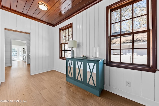 interior space featuring baseboards, light wood-type flooring, plenty of natural light, and wood ceiling