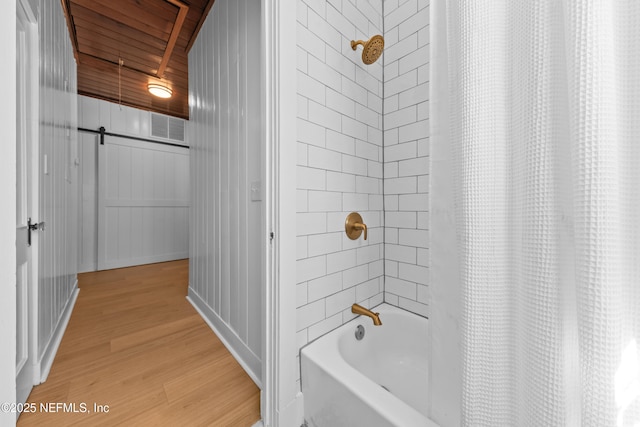 bathroom featuring visible vents, shower / bath combo with shower curtain, and wood finished floors