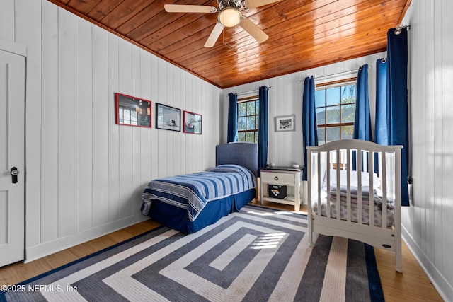 bedroom featuring wooden ceiling, baseboards, a ceiling fan, and wood finished floors