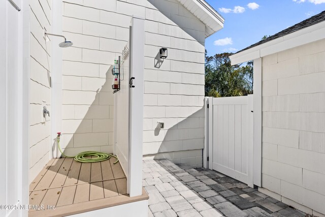 view of exterior entry featuring a patio area and fence