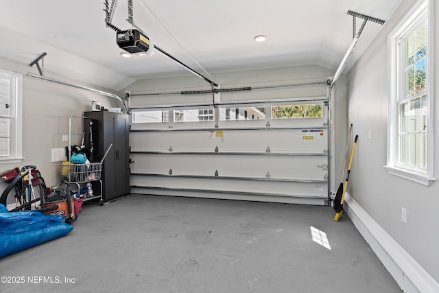 garage featuring a garage door opener and baseboards