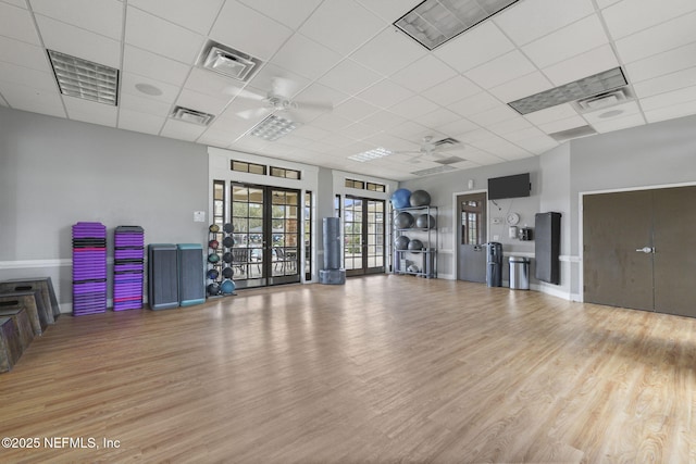 exercise room with ceiling fan, visible vents, wood finished floors, and french doors