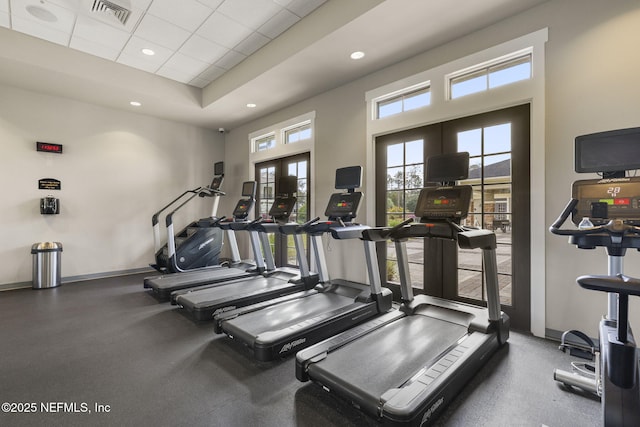 exercise room with a drop ceiling, recessed lighting, visible vents, baseboards, and french doors