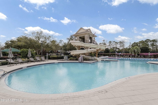 pool with a water slide and a patio