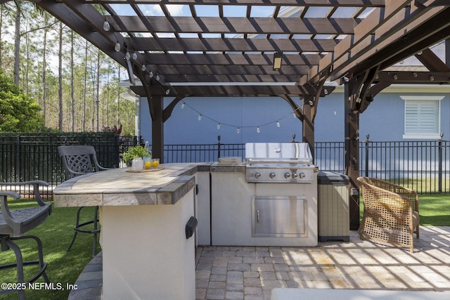 view of patio / terrace featuring area for grilling, fence, outdoor dry bar, grilling area, and a pergola