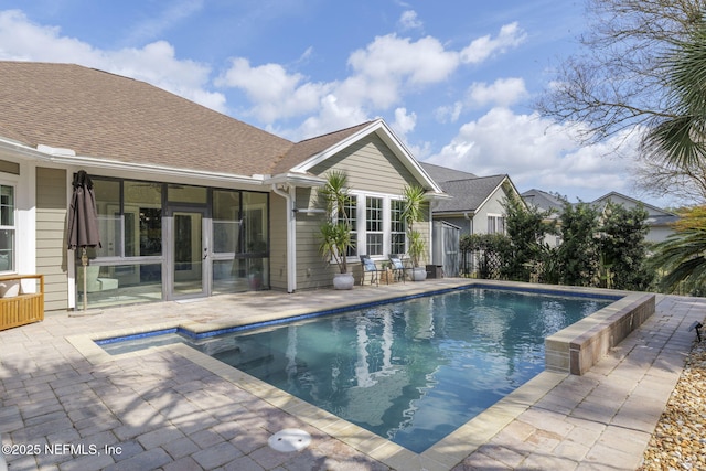 pool with a sunroom and a patio area