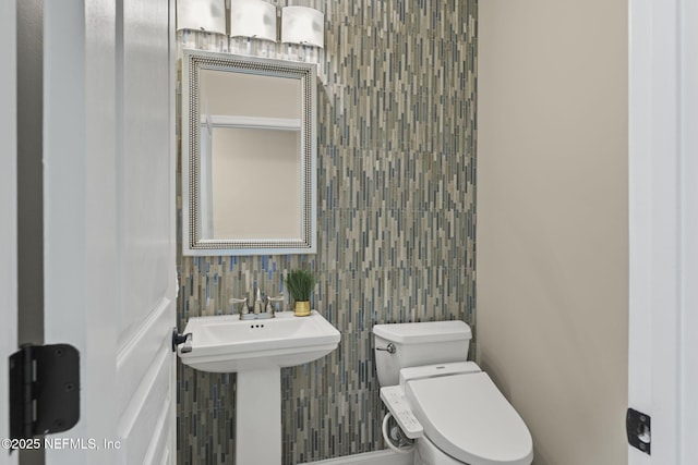 bathroom with tile walls and toilet