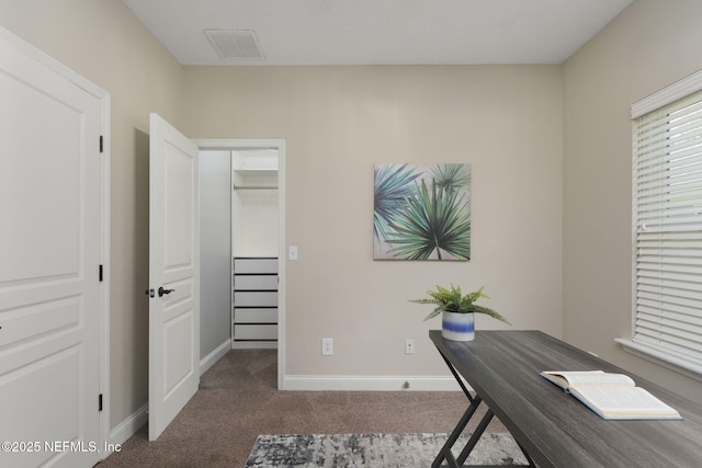 carpeted office featuring visible vents and baseboards