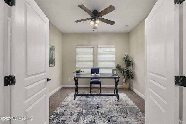 carpeted home office with a textured ceiling, baseboards, and a ceiling fan