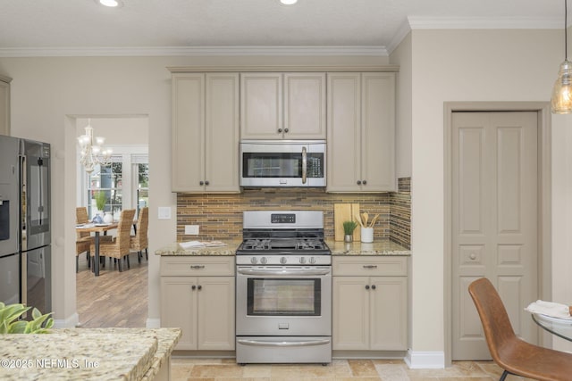 kitchen featuring appliances with stainless steel finishes, cream cabinetry, and crown molding