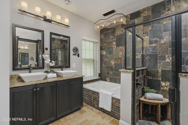 bathroom with tiled shower, a sink, a textured ceiling, and a bath