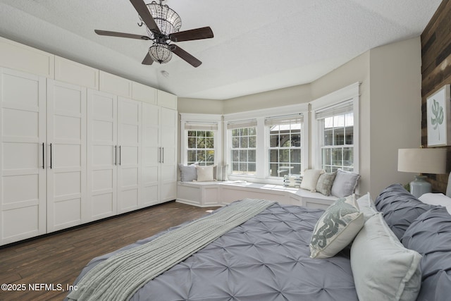 bedroom featuring dark wood-style floors, ceiling fan, and a textured ceiling