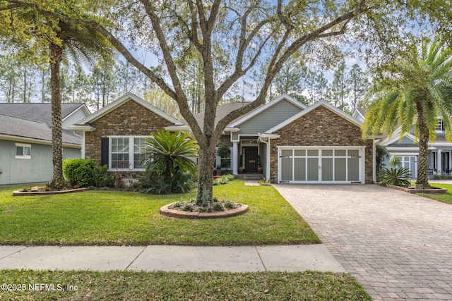 view of front of house with a garage, brick siding, decorative driveway, and a front yard