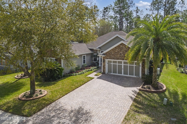 view of front of house with stone siding, a front lawn, and decorative driveway