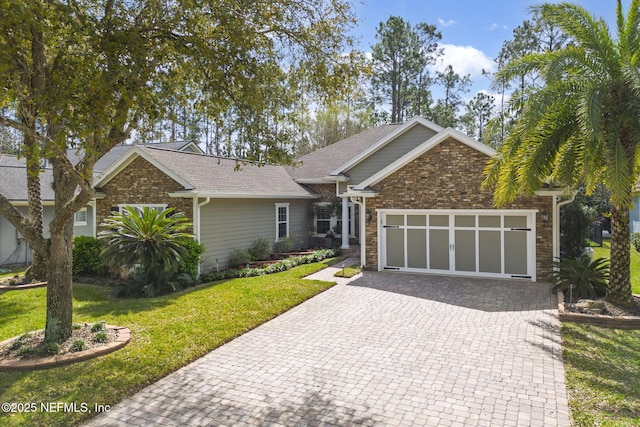 view of front of property featuring a garage, a front lawn, decorative driveway, and brick siding