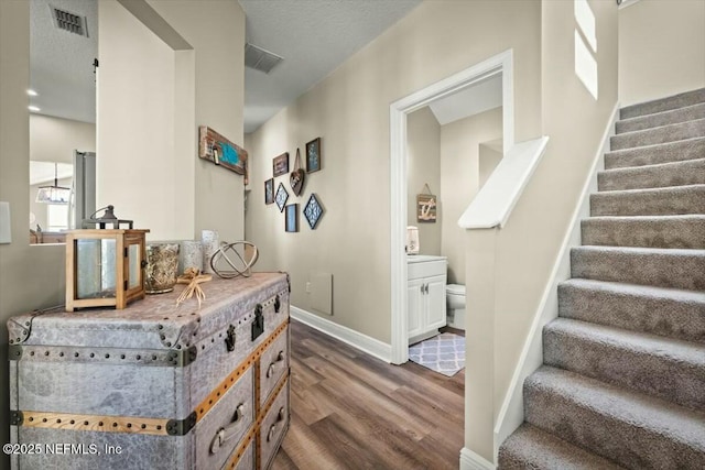 interior space featuring visible vents, dark wood finished floors, baseboards, and stairs