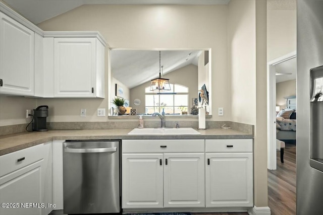 kitchen featuring lofted ceiling, white cabinets, a sink, and stainless steel dishwasher