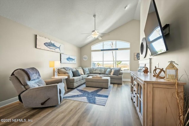 living room with high vaulted ceiling, wood finished floors, a ceiling fan, and baseboards