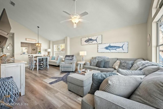 living room featuring high vaulted ceiling, wood finished floors, visible vents, and a ceiling fan