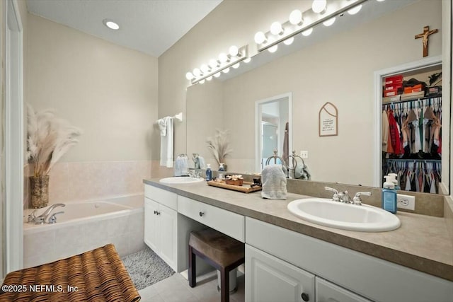 full bath featuring double vanity, a sink, a bath, and tile patterned floors