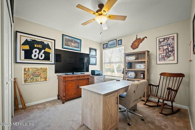 office space featuring baseboards, a ceiling fan, and light colored carpet