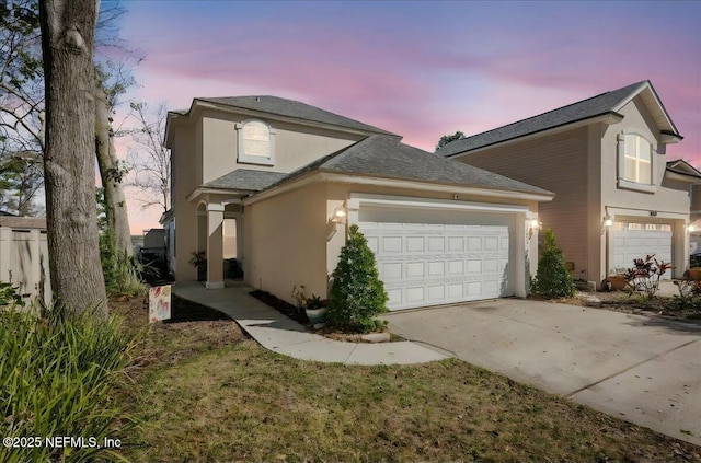 view of property exterior featuring a garage, concrete driveway, roof with shingles, and stucco siding