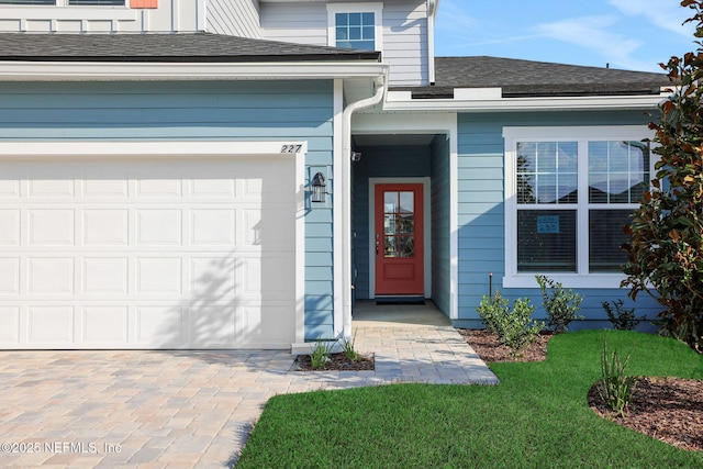 property entrance featuring a garage and roof with shingles