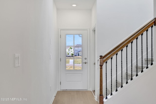 doorway to outside featuring stairs, light wood-type flooring, and baseboards