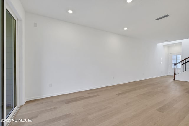 spare room featuring recessed lighting, visible vents, baseboards, stairway, and light wood-type flooring