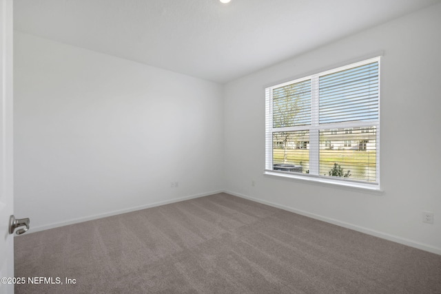 unfurnished room with carpet flooring and baseboards