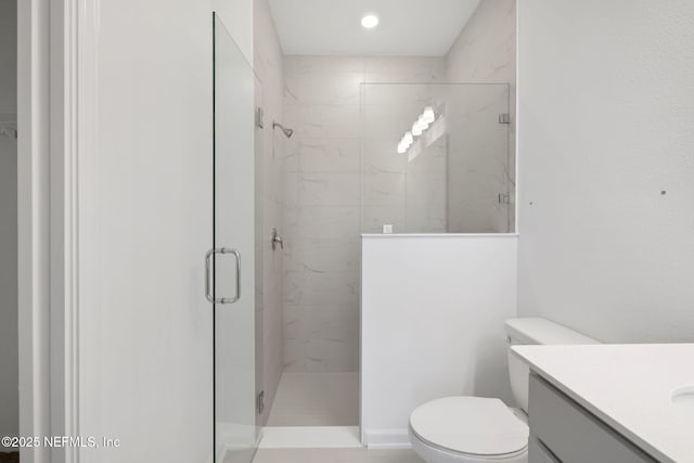 full bath featuring toilet, a shower stall, and vanity