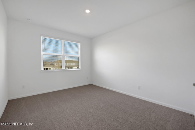 empty room featuring carpet flooring and baseboards