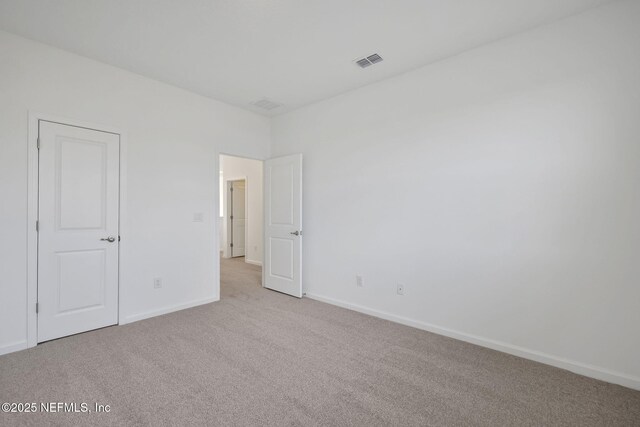 unfurnished bedroom featuring visible vents, light carpet, and baseboards