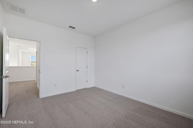 unfurnished bedroom with light carpet, visible vents, and baseboards