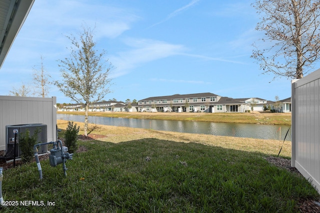 view of yard with central AC unit, a water view, and a residential view