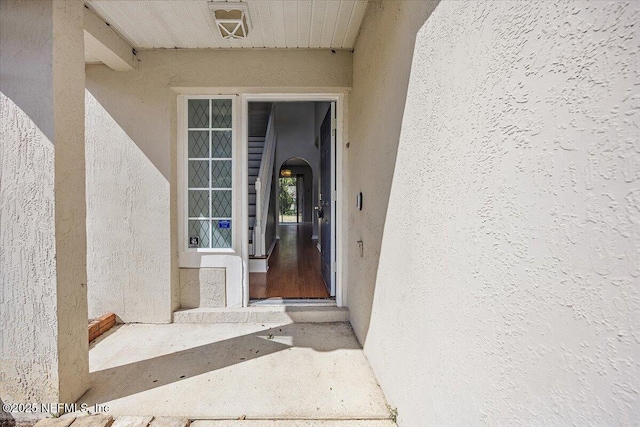 doorway to property featuring stucco siding